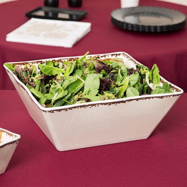 An American Metalcraft antique white melamine square bowl filled with green salad.