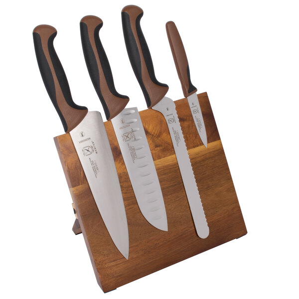 A Mercer Culinary Millennia Colors knife set on an acacia magnetic board.