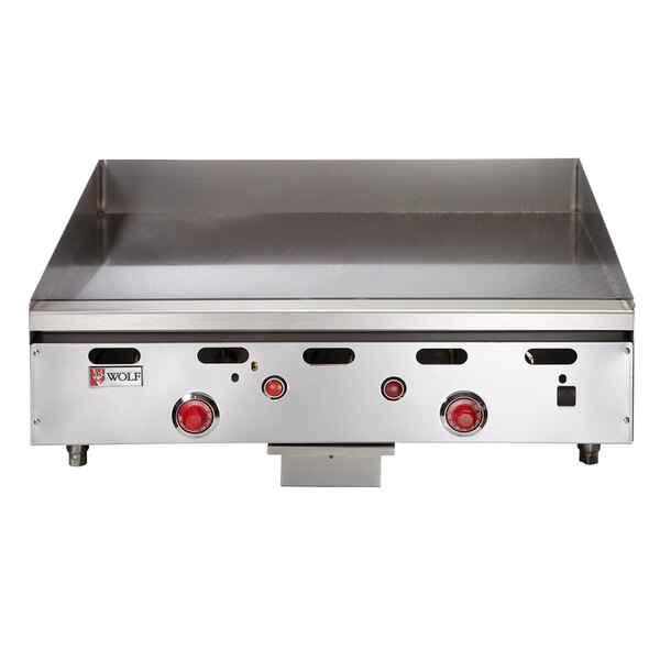 A Wolf natural gas countertop griddle with red knobs.