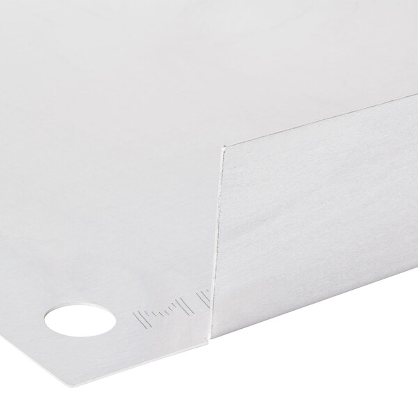 A close-up of a white stainless steel surface with holes.