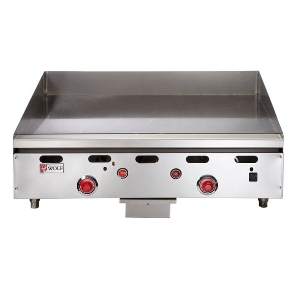 A Wolf stainless steel countertop griddle with red knobs.