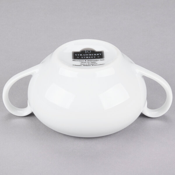 A white porcelain sugar bowl with two handles.