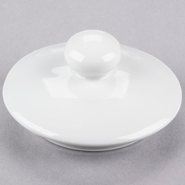 A white porcelain sugar bowl with a round lid and handle.