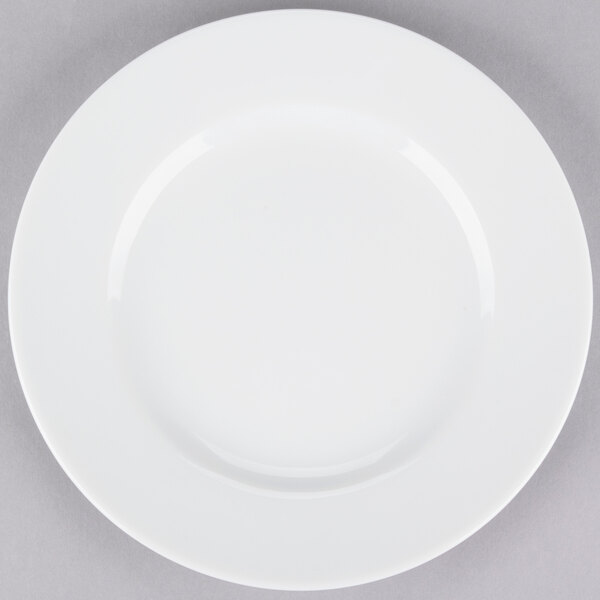 A white 10 Strawberry Street porcelain plate with a white rim on a gray surface.