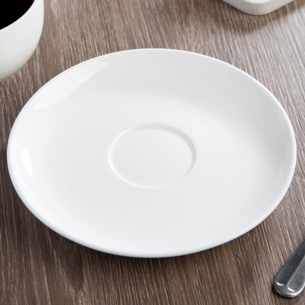 A white 10 Strawberry Street Ricard porcelain saucer on a table.