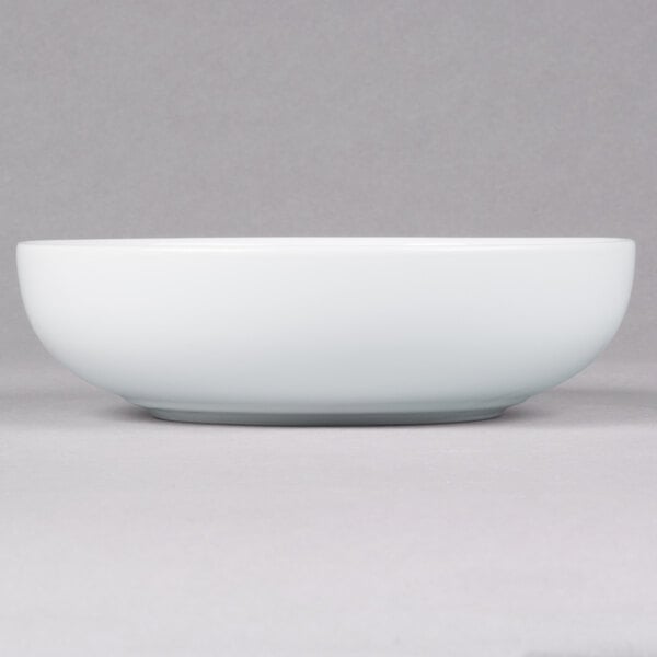 A white bowl on a grey surface.
