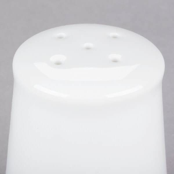 A white porcelain salt shaker with holes.