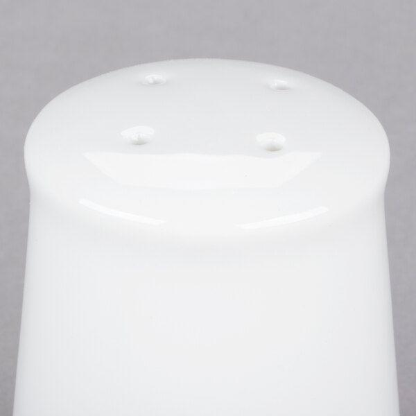 A white porcelain salt shaker with holes.