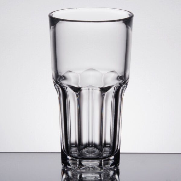 An Arcoroc stackable beverage glass with a rim on a table.