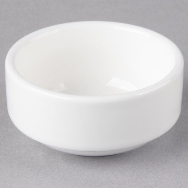 A close up of a 10 Strawberry Street white porcelain ramekin on a gray surface.
