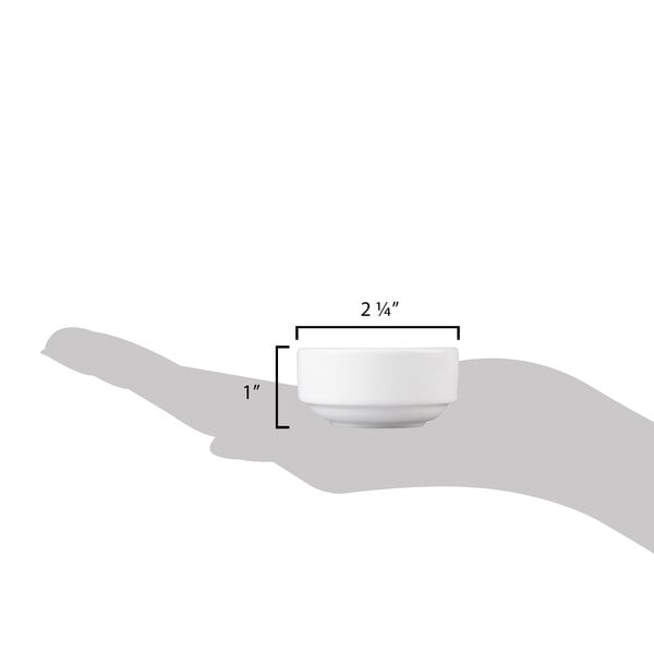 A hand holding a small white 10 Strawberry Street Ramekin.