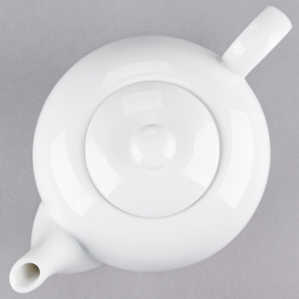 A close-up of a white 10 Strawberry Street porcelain teapot with a lid and a handle.