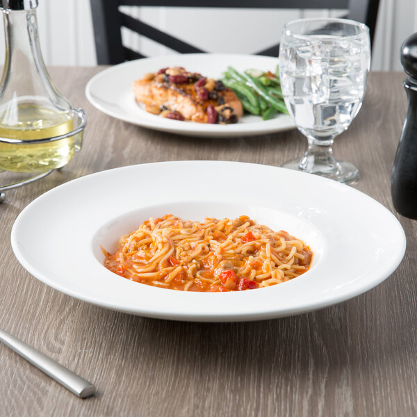 A plate of pasta and meatballs in a 10 Strawberry Street white porcelain pasta bowl on a table.
