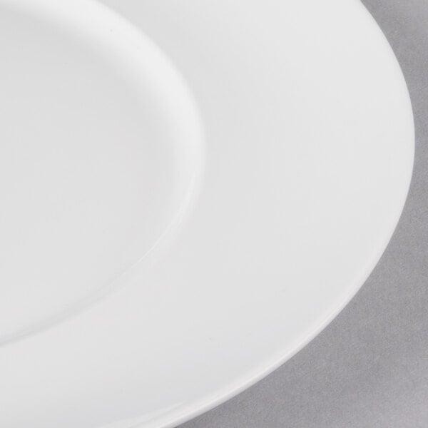 A close-up of a 10 Strawberry Street white porcelain luncheon plate with a white rim.