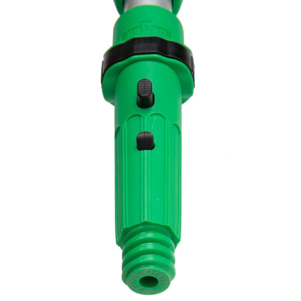 An Unger green and black plastic telescopic pole with a black button.