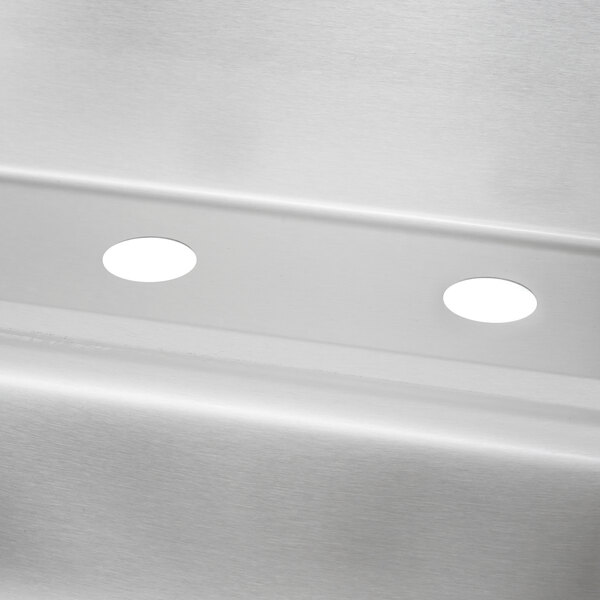 A stainless steel Advance Tabco hand sink with a backsplash.