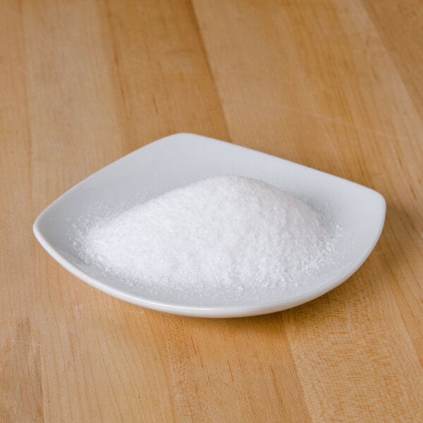 White square dish on light wood surface full on fine white table salt