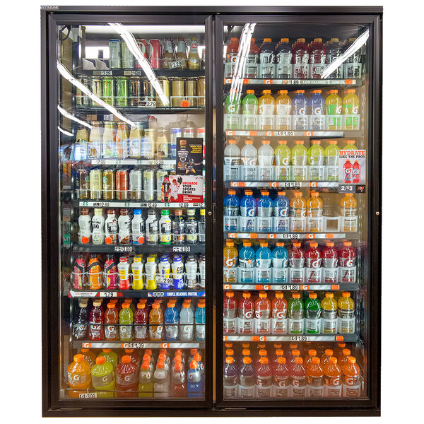 A room with Styleline walk-in cooler merchandiser doors filled with shelves of drinks.