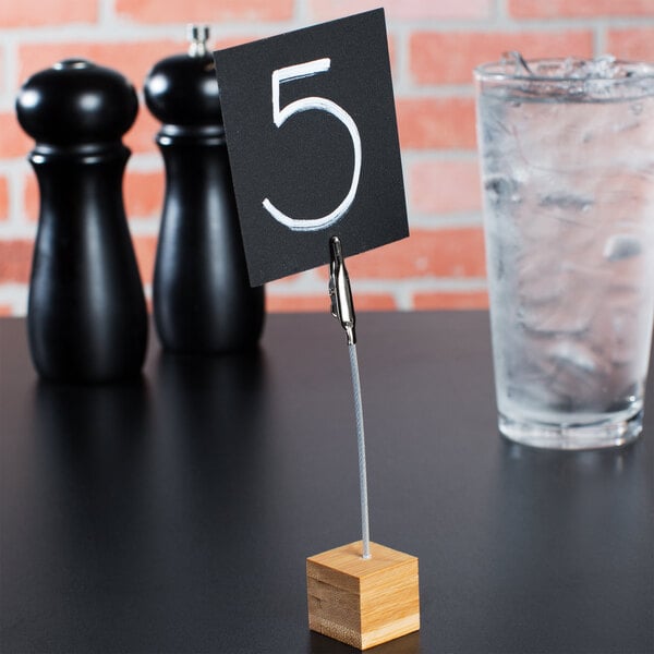 A black square table number card on a wooden stand.