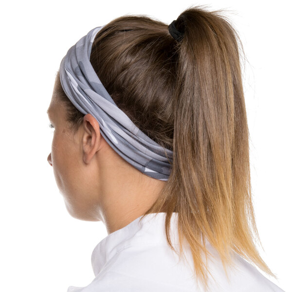 A woman wearing a camo Headsweats headband.