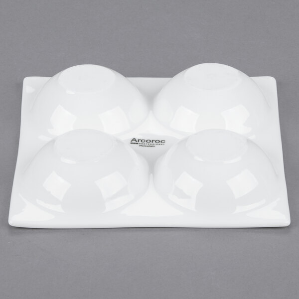 An Arcoroc white porcelain dish with four compartments.