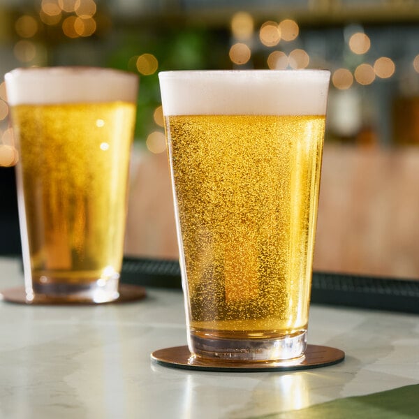 A clear 16 oz. rim tempered mixing or pint glass filled with a light, bubbly beverage and topped with foam.