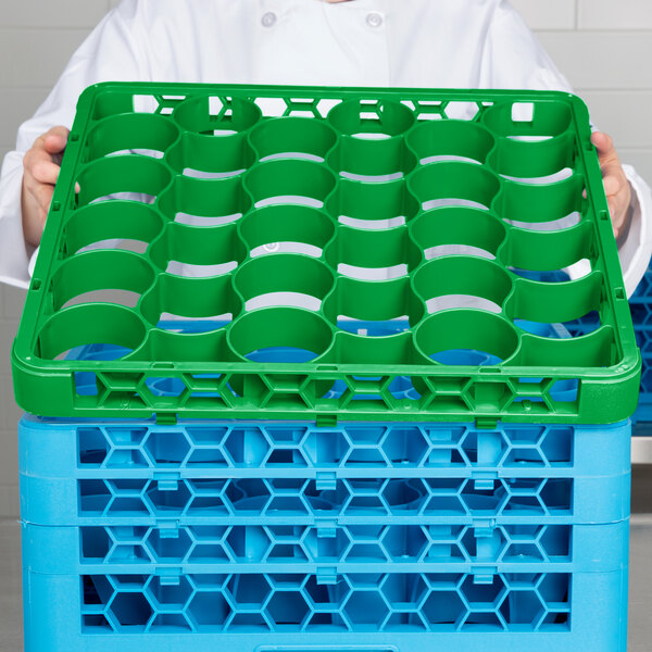 A chef holding a green Carlisle glass rack extender.