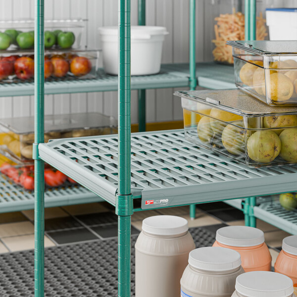 A green Metro PR2460NK3 Super Erecta Pro shelf measuring 24 inches by 60 inches, used for storage in a commercial setting.