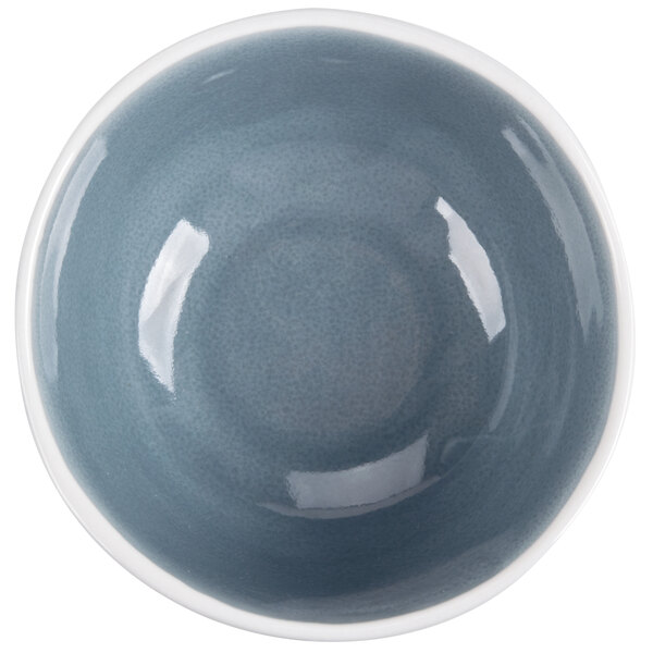 A close-up of an Arcoroc blue porcelain bowl with a white rim.