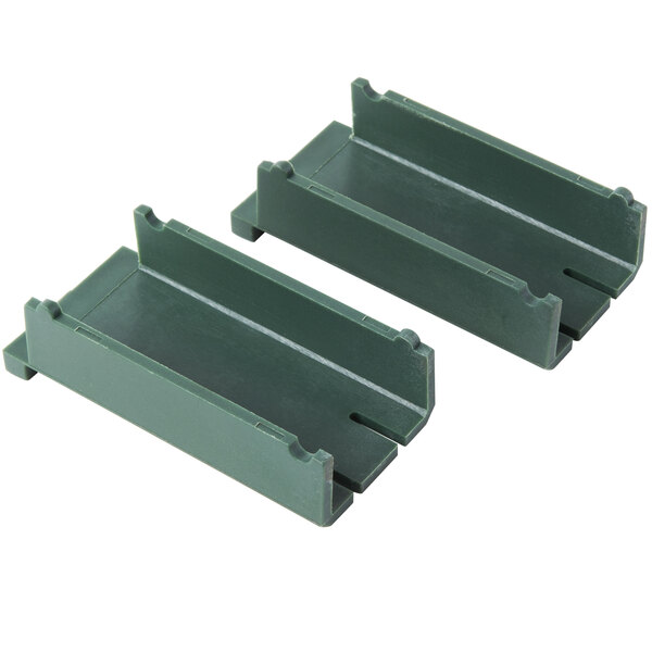 Two green plastic shelves with two holes.