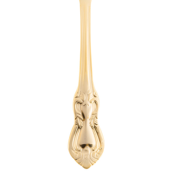 A close up of a 10 Strawberry Street gold plated stainless steel butter knife with a decorative design.