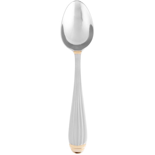 A silver spoon with gold trim and an egg-shaped handle.