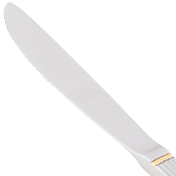 A white knife with a gold handle and silver blade.
