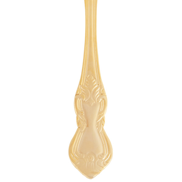 A close-up of a 10 Strawberry Street Crown Royal stainless steel dinner spoon with a gold plated handle.