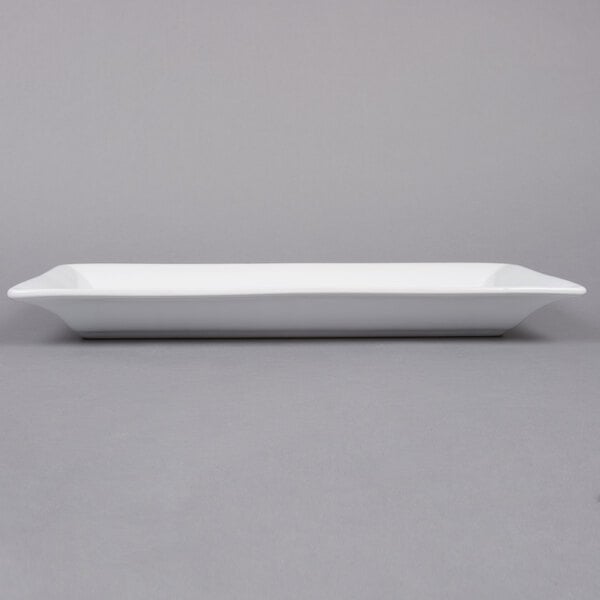 An American Metalcraft white rectangular stoneware platter on a gray surface.