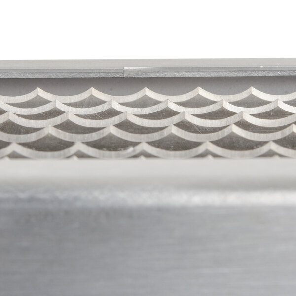 A close-up of a metal surface with a silver metal Edlund ARC! XL blade assembly.
