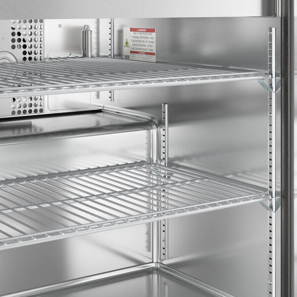 A True stainless steel refrigerated sandwich prep table with shelves.