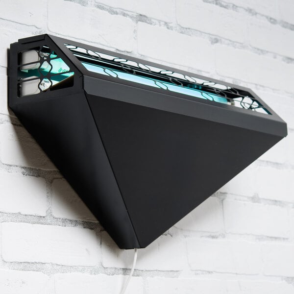 A black Curtron wall sconce with a green light on it.
