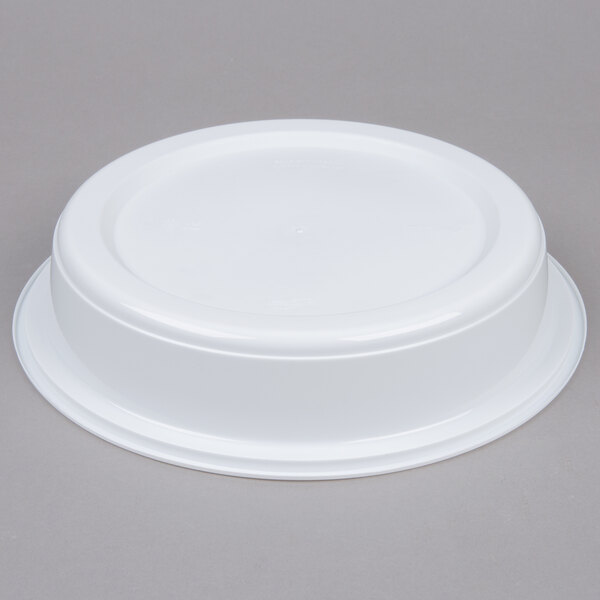 A white plastic bowl with a lid on a gray surface.