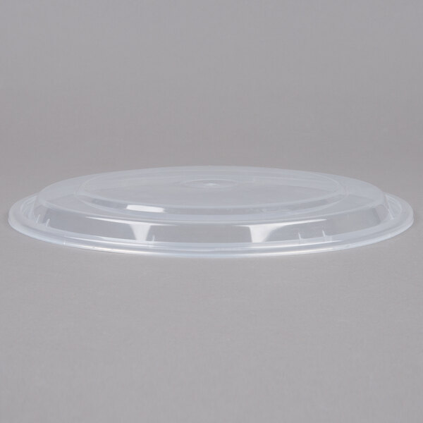 A clear plastic lid on a white 48 oz. round microwavable container.