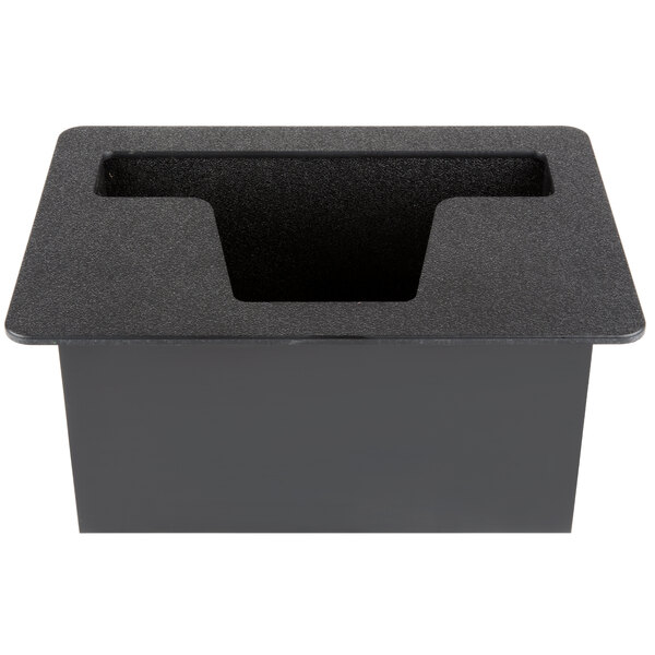 A black rectangular tray with a hole in it on a grey surface.