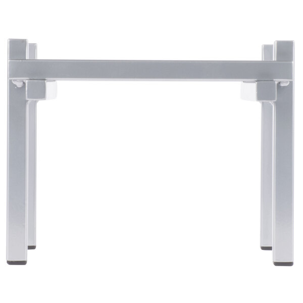 A white metal table with a silver metal rectangular base with legs.