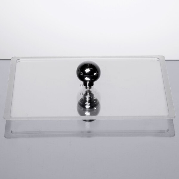 A clear polycarbonate lid with a black ball on top.