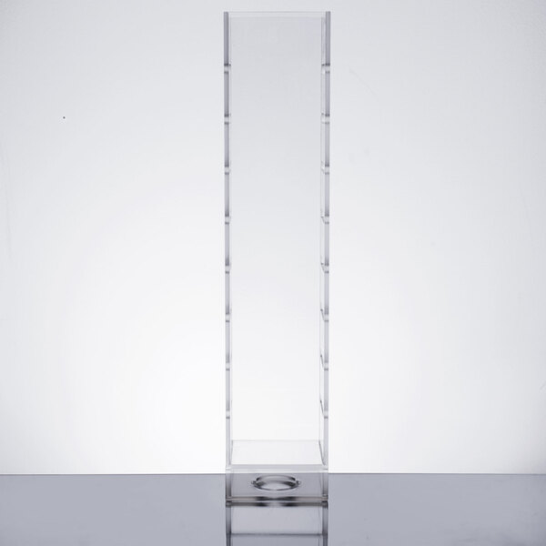 A clear acrylic infusion chamber on a clear plastic shelf.