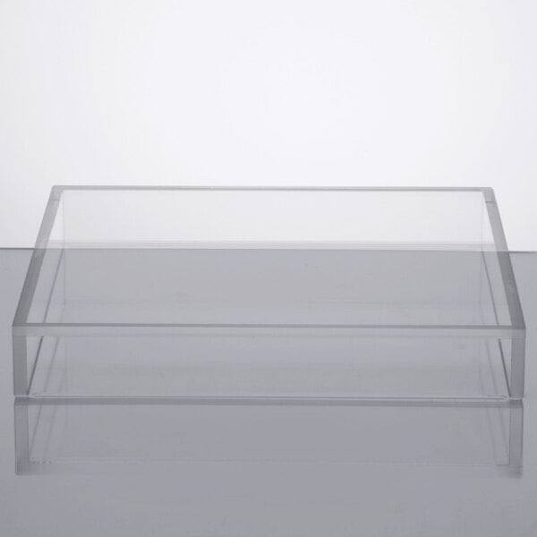 A clear rectangular lid on a white surface.