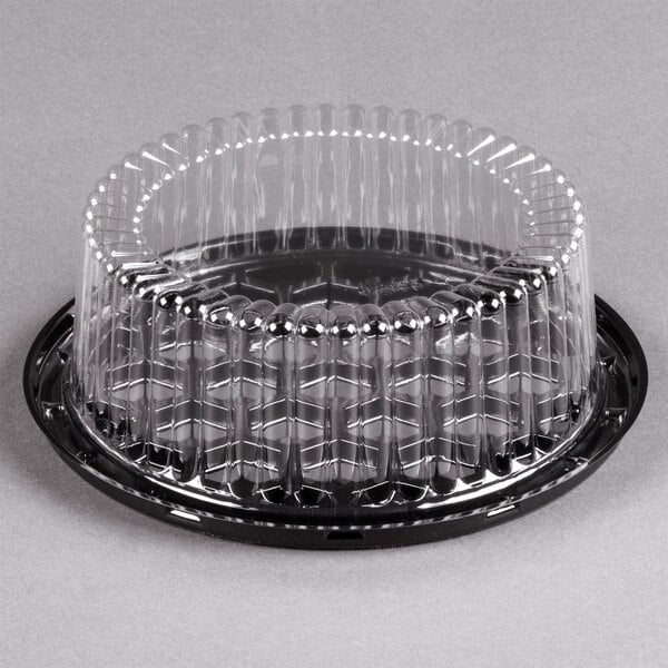 A clear plastic container with a clear plastic lid containing a cake.