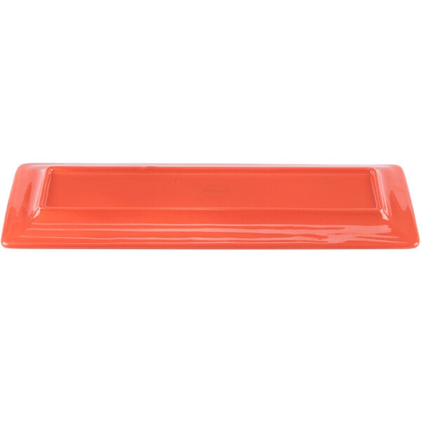 A rectangular orange tray with a carved design.
