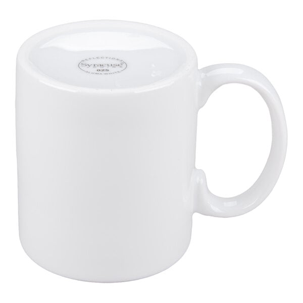 A plain white porcelain mug is shown upside down with a visible handle and a stamp on the bottom.