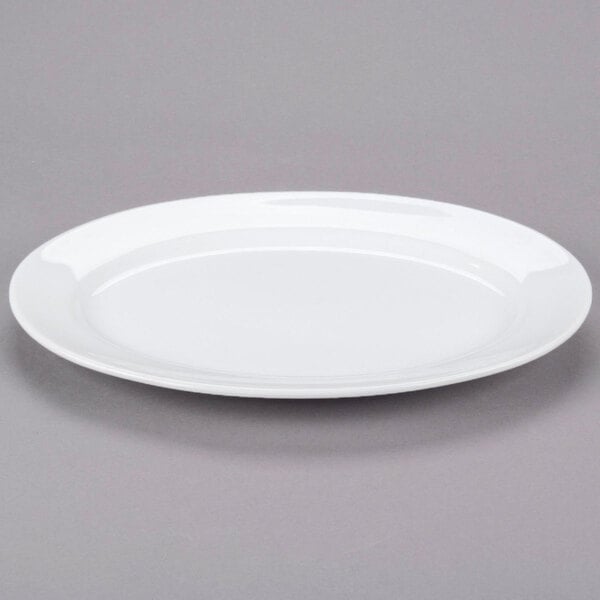 A Libbey Aluma White Porcelain Platter with a rim on a gray surface.