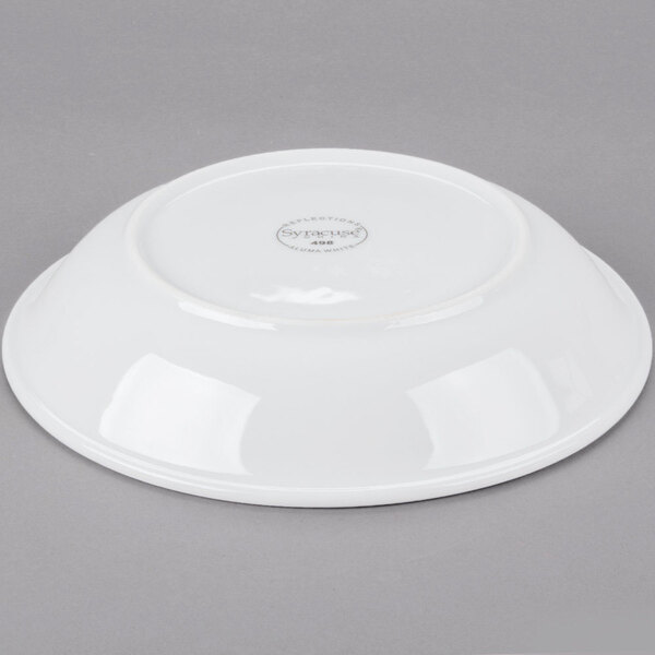 A Libbey white porcelain shallow bowl on a gray surface.